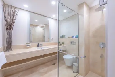 a bathroom with a shower and a sink and a toilet at High Standard 2-Bedroom in Mangroovy Residence, Pool View & Beach in Hurghada