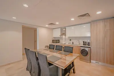 a kitchen with a wooden table and a dining room at High Standard 2-Bedroom in Mangroovy Residence, Pool View & Beach in Hurghada