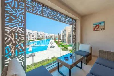 a living room with a view of the pool at High Standard 2-Bedroom in Mangroovy Residence, Pool View & Beach in Hurghada