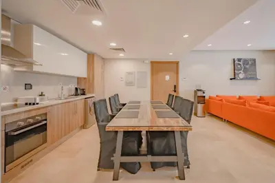 a kitchen and dining room with a table and chairs at High Standard 2-Bedroom in Mangroovy Residence, Pool View & Beach in Hurghada