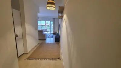 a hallway leading to a living room with a light fixture at Soma Bay Ambiance - Relaxed Apartment - Next to The Breakers in Hurghada