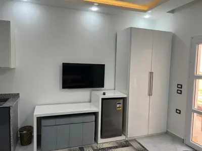 a kitchen with a tv and a white cabinet at Boka Bay One in Hurghada