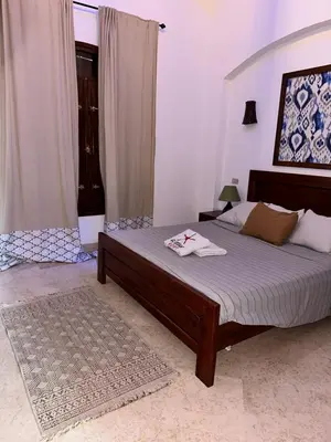 a bedroom with a bed with a wooden frame at Sabina 1br apartment Lagoon view with shared pool By BFG Beit Fel Gouna in Hurghada