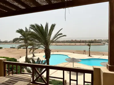 a view of a swimming pool from a balcony at Sabina 1br apartment Lagoon view with shared pool By BFG Beit Fel Gouna in Hurghada