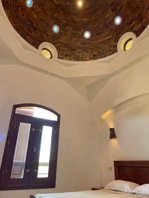 a bedroom with a bed and a ceiling with a window at Sabina 1br apartment Lagoon view with shared pool By BFG Beit Fel Gouna in Hurghada