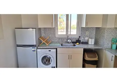 a kitchen with a refrigerator and a washing machine at El Gouna Waterside, 2-Bd Ground Floor Sleeps 4 Persons in El Gouna