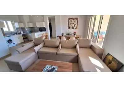 a living room with a couch and a kitchen at El Gouna Waterside, 2-Bd Ground Floor Sleeps 4 Persons in El Gouna