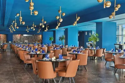 a dining room with tables and chairs and blue walls at Pickalbatros Blu Spa Resort - Adults Friendly 16 Years Plus- Ultra All-Inclusive in Hurghada