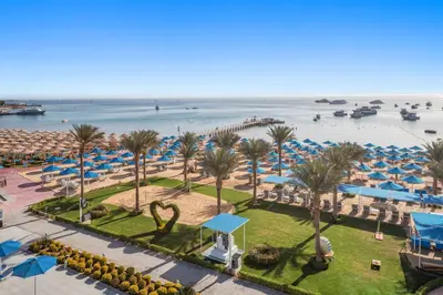 a view of a beach with palm trees and umbrellas at Pickalbatros Blu Spa Resort - Adults Friendly 16 Years Plus- Ultra All-Inclusive in Hurghada