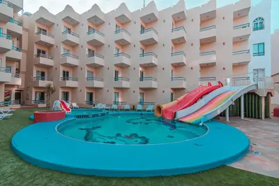 a pool with a slide in front of a building at Dexon Roma Hotel in Hurghada