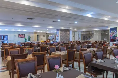 a restaurant with tables and chairs in a room at Dexon Roma Hotel in Hurghada