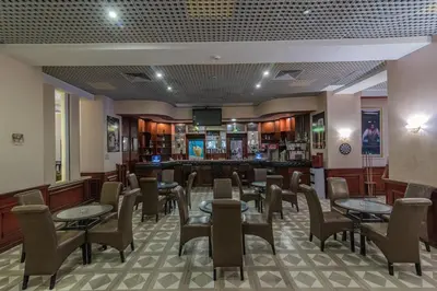 a restaurant with tables and chairs and a bar at Dexon Roma Hotel in Hurghada