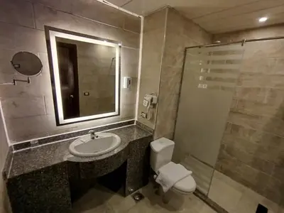 a bathroom with a sink and a toilet and a mirror at Dexon Roma Hotel in Hurghada