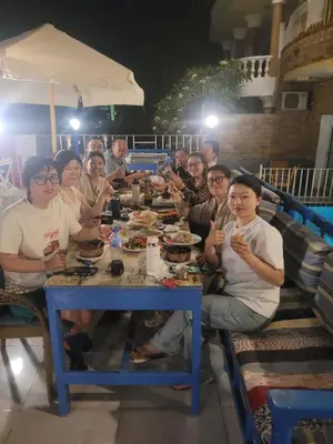 a group of people sitting at a table eating food at Blue Nile House in Luxor