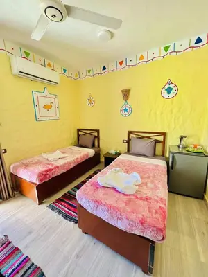 two beds in a room with flags on the wall at Nukud guest house in Aswan
