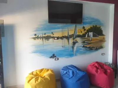 a tv on a wall with a painting on it at Nukud guest house in Aswan