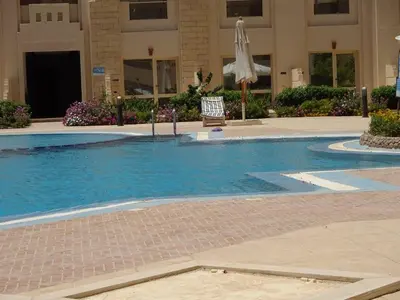 a swimming pool with a chair and an umbrella in a building at Florenza - sea view in Hurghada