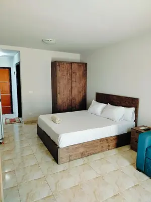 a bedroom with a large bed with a wooden headboard at Fully furnished Studio, At Tiba View, NUMBER R75 in Hurghada