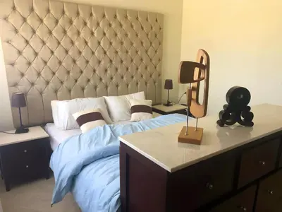 a bedroom with a large bed with a large headboard at Apartman Andalusie in Hurghada