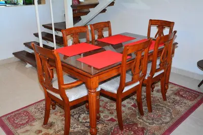 a wooden dining room table and chairs with red napkins at Prime Home The View Hurghada in Hurghada