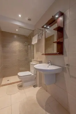 a bathroom with a sink and a toilet and a mirror at Cozy 2-Bedroom Apartment in G-Cribs, El Gouna. Terrace & Pool in Hurghada
