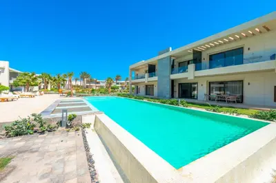 a swimming pool in front of a building at Cozy 2-Bedroom Apartment in G-Cribs, El Gouna. Terrace & Pool in Hurghada