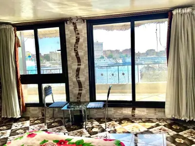 a room with two chairs and a room with windows at Nubian Dreams Guest House in Aswan