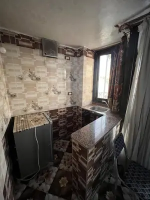 a dirty kitchen with a sink and a refrigerator at Nubian Dreams Guest House in Aswan
