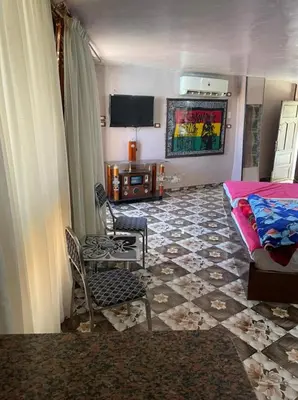 a living room with a bed and a table and chairs at Nubian Dreams Guest House in Aswan