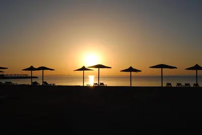 a group of umbrellas on the beach at sunset at Cecelia in Hurghada