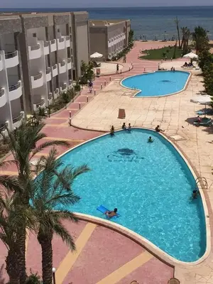 an overhead view of a large swimming pool next to the beach at Cecelia in Hurghada