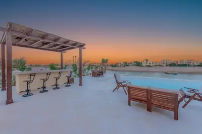 a patio with a pool and tables and chairs at Fresh Breeze High-End 2BR Villa with Private Pool, Sabina, El Gouna in Hurghada