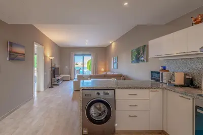 a kitchen with a washer and a living room at 3BR Family Villa in Sabina, El Gouna. Lagoon & Private Pool in Hurghada