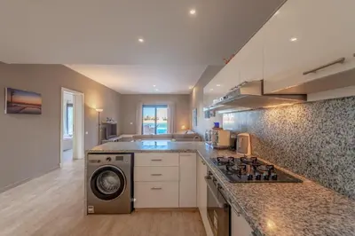 a kitchen with a stove top oven next to a counter at 3BR Family Villa in Sabina, El Gouna. Lagoon & Private Pool in Hurghada