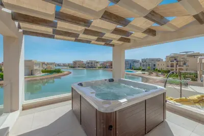 a hot tub on a balcony with a view of a river at Light-Filled 4-Bedroom Villa in Tawila, El Gouna. Jacuzzi & Lagoon in Hurghada