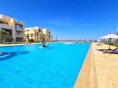 a large blue swimming pool in a resort at Luxurious Sea view 2 BR & private Garden to the pool at Mangroovy in Hurghada