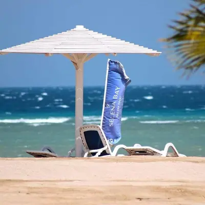 a pair of chairs and an umbrella on a beach at Selena Bay Resort luxury 1 bedroom Apartments in Hurghada