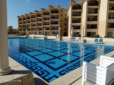 a swimming pool in front of a building at Selena Bay Resort luxury 1 bedroom Apartments in Hurghada