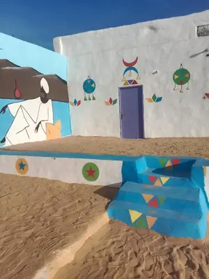 a painting of a building on the beach at بيت شمس in Aswan