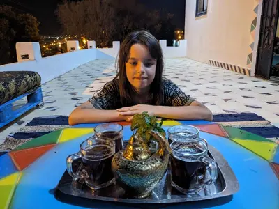 a young girl sitting at a table with a tray of food at بيت شمس in Aswan