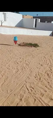 a blue frisbee sitting in the sand on a beach at بيت شمس in Aswan
