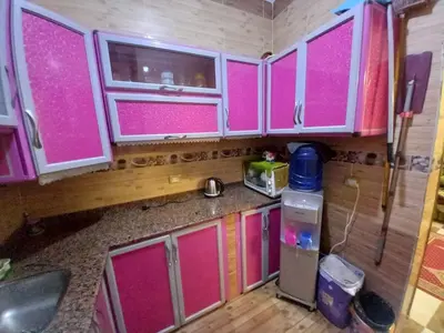 a kitchen with pink doors and a counter top at Sabrina home in Aswan
