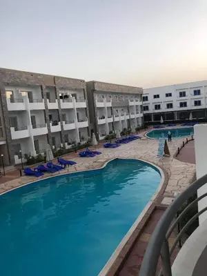 a hotel with a swimming pool in front of a building at Cecelia resort in Hurghada