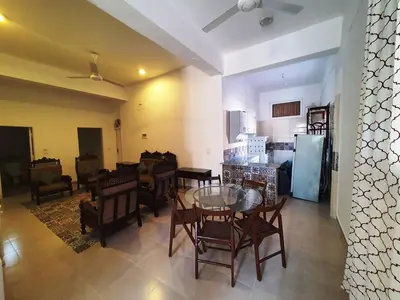 a living room with a table and chairs and a kitchen at Family House in Luxor