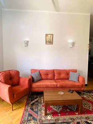 a living room with a red couch and a coffee table at Temple House Luxor in Luxor