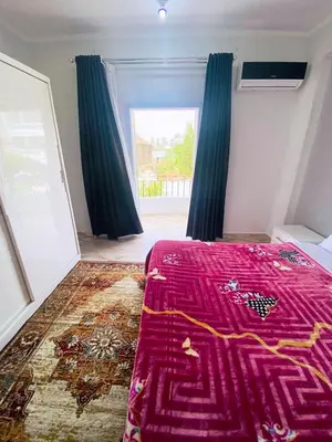 a bedroom with a purple bed and a window at Temple House Luxor in Luxor