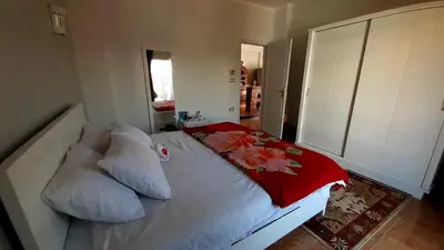 a bedroom with a white bed with flowers on it at Temple House Luxor in Luxor