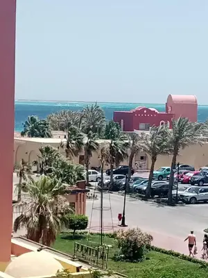 a view of a parking lot with palm trees and cars at Outstanding Apartment with Marina Hurghada view in Hurghada