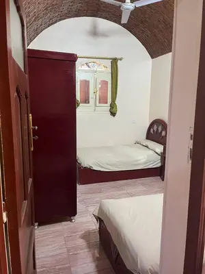 a room with two beds and an open door at Hamd Nubian Guest House in Aswan