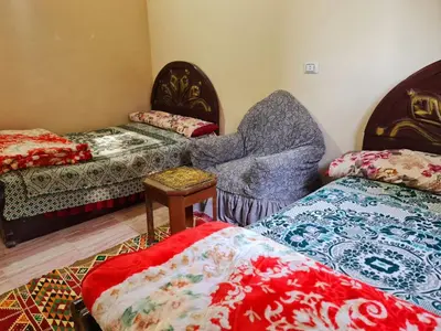 a room with two beds and a couch and a chair at Hamd Nubian Guest House in Aswan